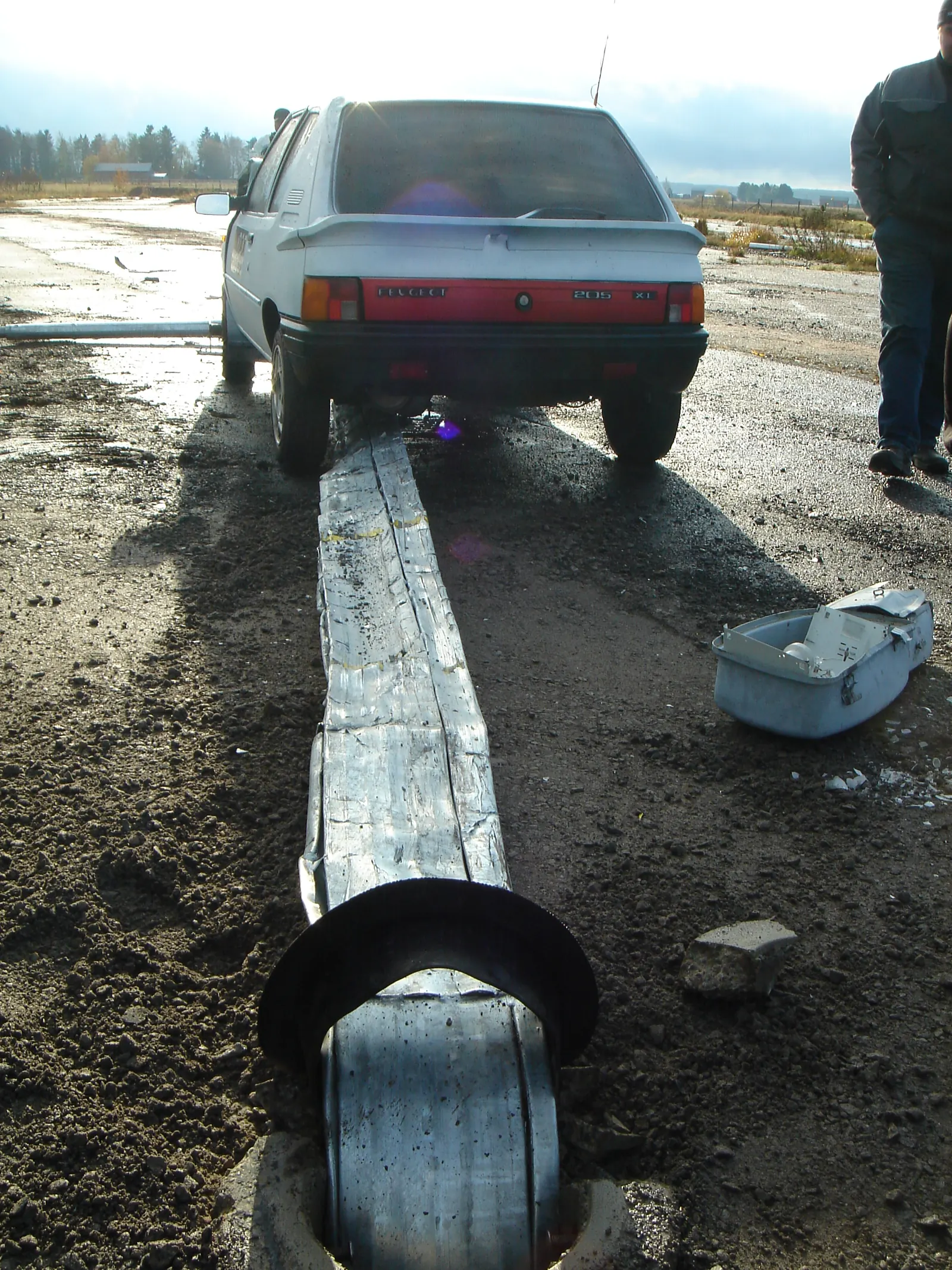 The test pole folded down from its base under the stopped test car, in one piece.